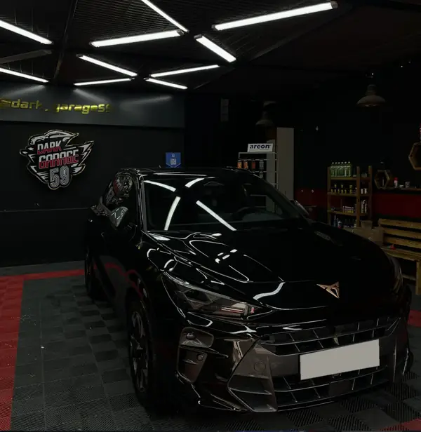 Stüdyoda parlak siyah Cupra, arkada Dark Garage 59 tabelası