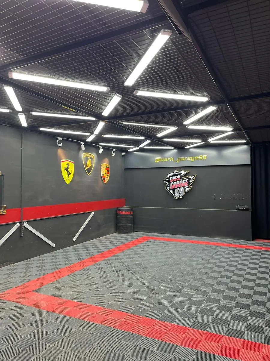 Dark Garage 59 stüdyosu: LED tavan aydınlatması, kırmızı çizgili zemin ve duvarda Dark Garage 59 amblemi
